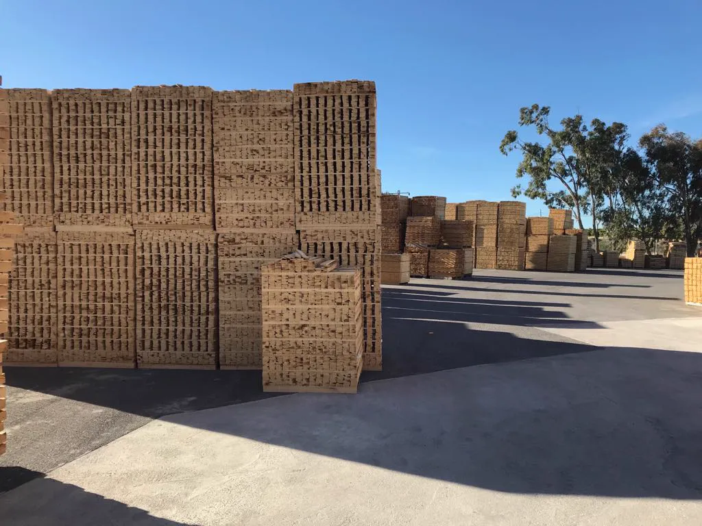 Patio de Palets García en Algorfa con pilas de palets y un camión cargado